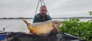 Zawodnik Carp Servis Václavík prezentuje złowioną rybę podczas jesiennej karpiowej zasiadki