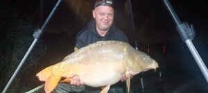 Karpiarz z karpiem podczas zawodów Jesień z Carp Servis Václavík i jesiennego karpiowania